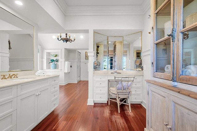 bathroom with vanity, hardwood / wood-style floors, ornamental molding, and a chandelier