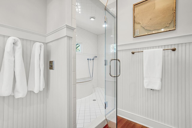 bathroom with a shower with shower door and hardwood / wood-style floors