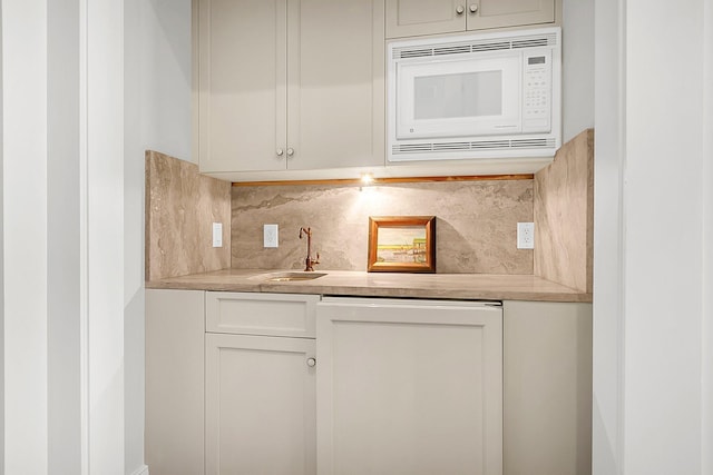 kitchen with sink, backsplash, and white microwave