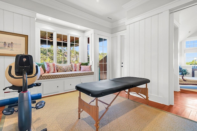 workout room with ornamental molding and light hardwood / wood-style flooring