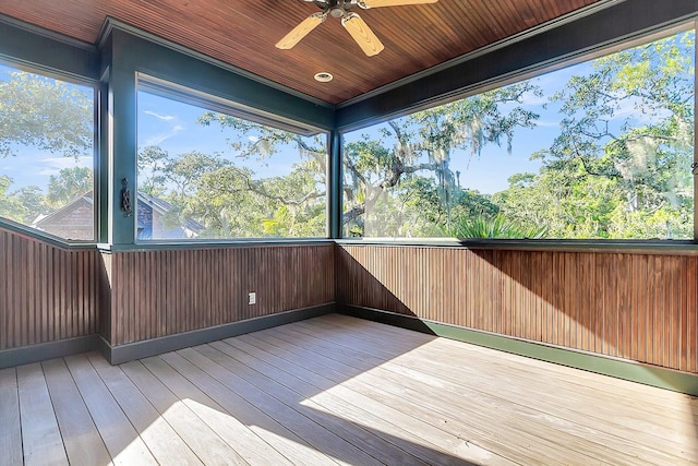 unfurnished sunroom featuring plenty of natural light, wooden ceiling, and ceiling fan