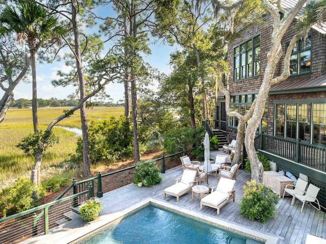 view of pool with a wooden deck and a rural view