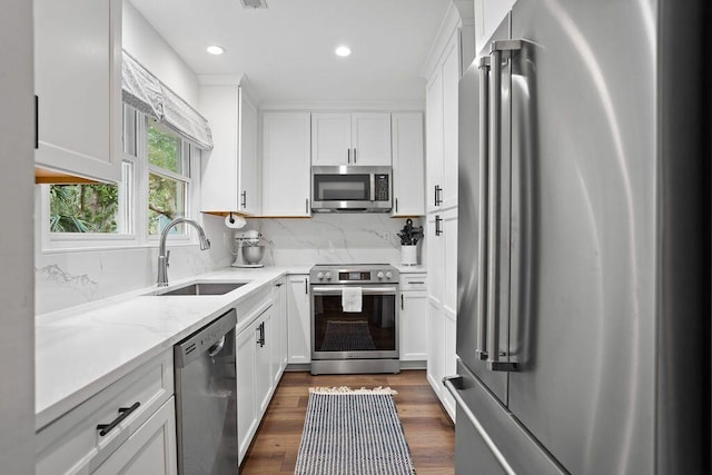 kitchen with dark wood-type flooring, white cabinetry, appliances with stainless steel finishes, and sink