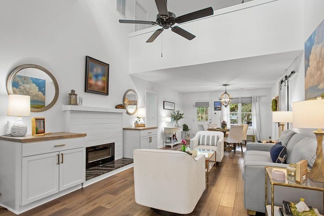 living room with dark wood-type flooring, ceiling fan, and a fireplace