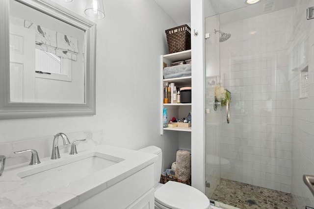 bathroom featuring toilet, vanity, and walk in shower