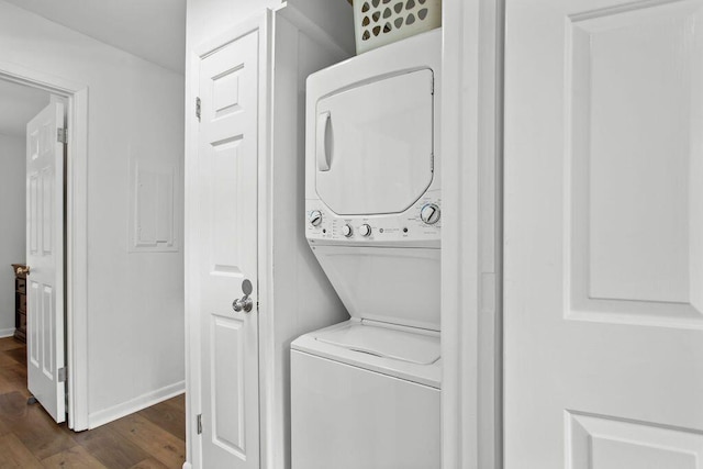 washroom featuring stacked washer / dryer and dark hardwood / wood-style flooring