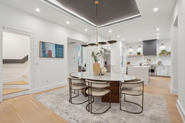 dining room featuring recessed lighting, baseboards, stairs, and light wood-type flooring
