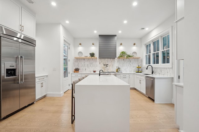 kitchen with stainless steel appliances, light wood-style floors, and open shelves