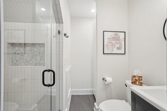full bathroom featuring toilet, vanity, baseboards, and a shower stall