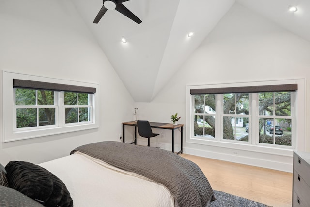 bedroom featuring wood finished floors, vaulted ceiling, and multiple windows