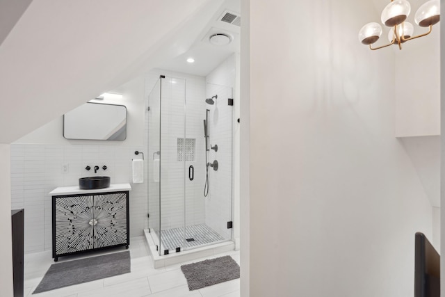 full bathroom with a shower stall, visible vents, vanity, and a chandelier