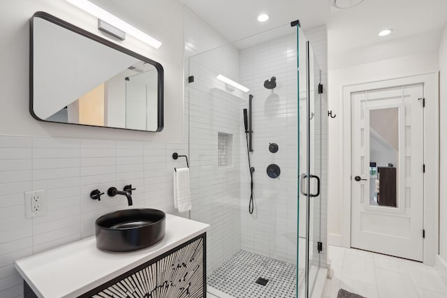 full bathroom with vanity, recessed lighting, tile walls, and a shower stall