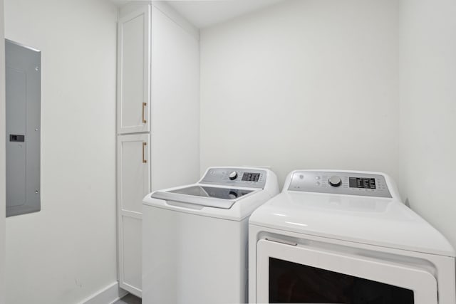 laundry area featuring cabinet space, washing machine and dryer, baseboards, and electric panel