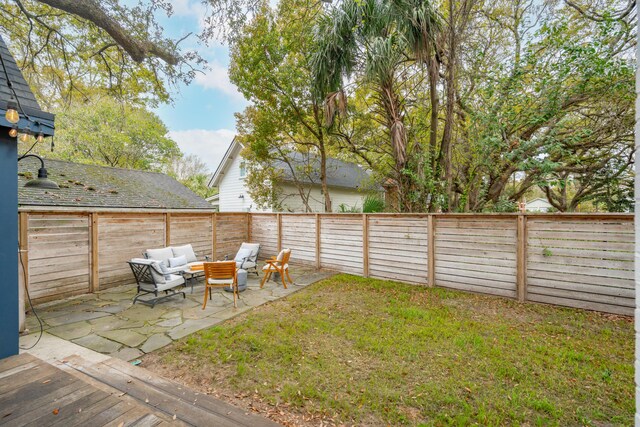 view of yard featuring a fenced backyard, a garage, an outdoor living space, and a patio area