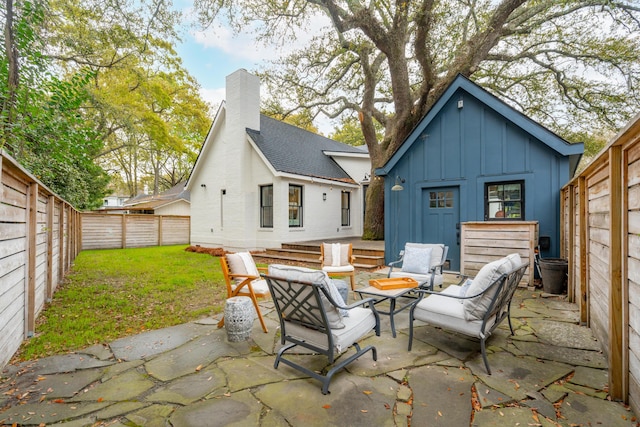 rear view of property featuring a fenced backyard, a chimney, a patio, and board and batten siding