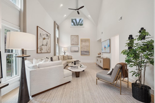 living room with a ceiling fan, high vaulted ceiling, baseboards, and visible vents