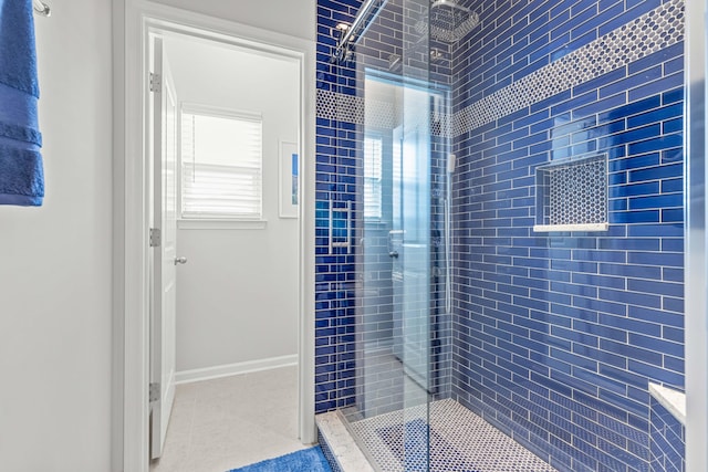 bathroom featuring tile patterned flooring and a tile shower