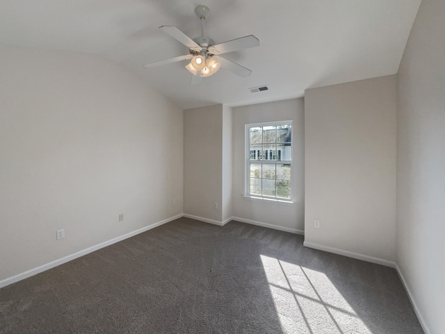 spare room with ceiling fan, lofted ceiling, and dark colored carpet