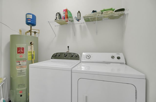 clothes washing area featuring washer and dryer and water heater