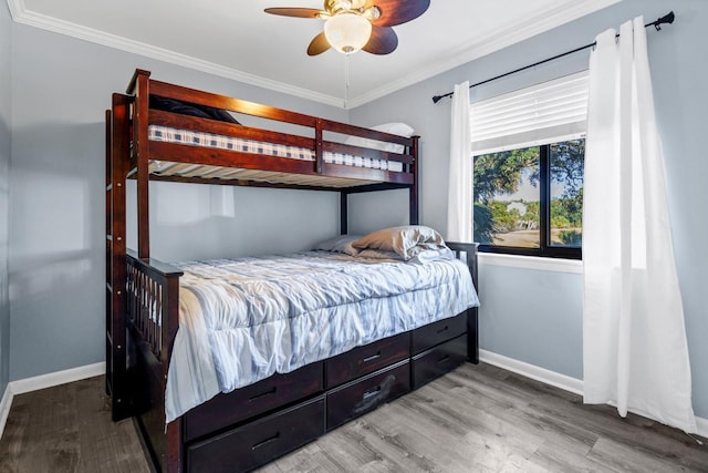 bedroom featuring ceiling fan, crown molding, and hardwood / wood-style flooring