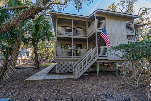 back of house with ceiling fan and a balcony