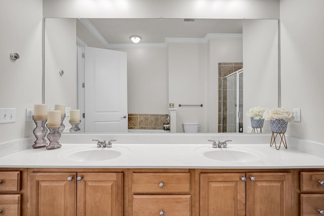 bathroom featuring an enclosed shower, vanity, ornamental molding, and toilet