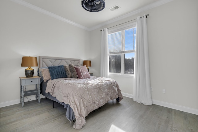 bedroom with wood-type flooring and ornamental molding