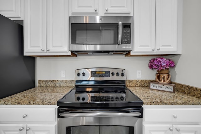 kitchen with white cabinetry, light stone countertops, and appliances with stainless steel finishes