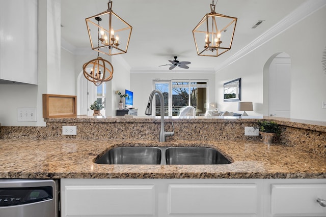 kitchen with hanging light fixtures, sink, stainless steel dishwasher, and white cabinets