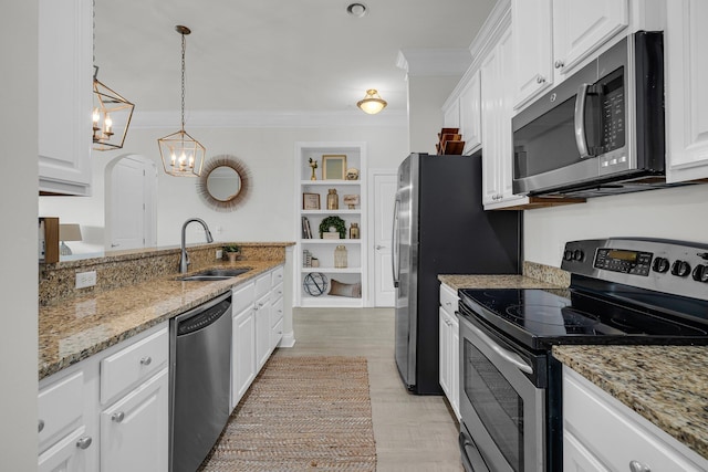 kitchen featuring sink, appliances with stainless steel finishes, pendant lighting, light stone countertops, and white cabinets