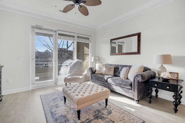 living room with ceiling fan, ornamental molding, and light wood-type flooring