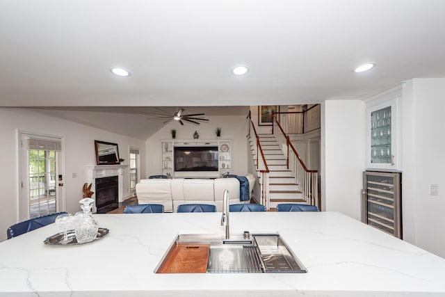 kitchen with a fireplace with flush hearth, recessed lighting, beverage cooler, a ceiling fan, and open floor plan