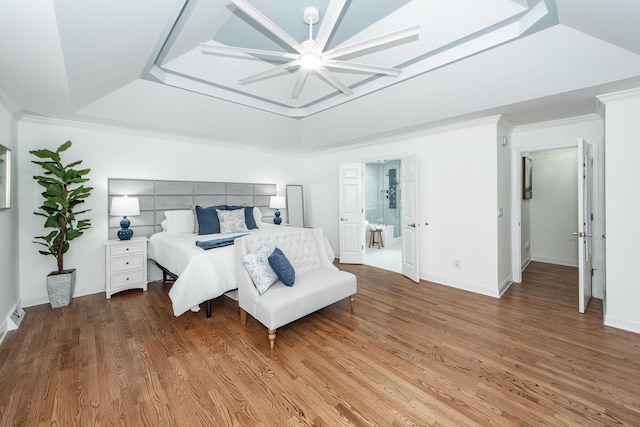 bedroom with ceiling fan, baseboards, wood finished floors, and a raised ceiling