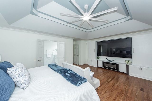 bedroom with a tray ceiling, a ceiling fan, and dark wood-type flooring