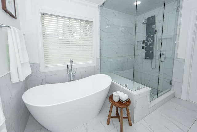 full bathroom with a soaking tub, wainscoting, marble finish floor, and a marble finish shower