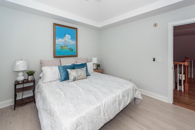 bedroom with baseboards and wood finished floors