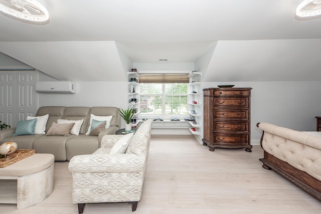 bedroom featuring a wall mounted air conditioner, visible vents, and light wood-style flooring