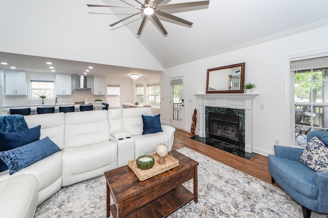 living room featuring plenty of natural light, recessed lighting, wood finished floors, ceiling fan, and a fireplace