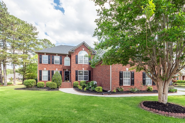 colonial house with brick siding and a front yard