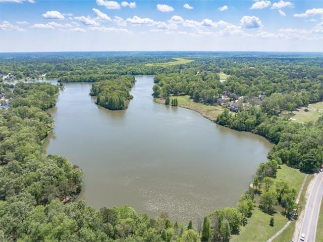 drone / aerial view featuring a water view and a wooded view