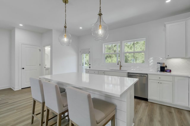 kitchen featuring white cabinetry, sink, dishwasher, and a kitchen island