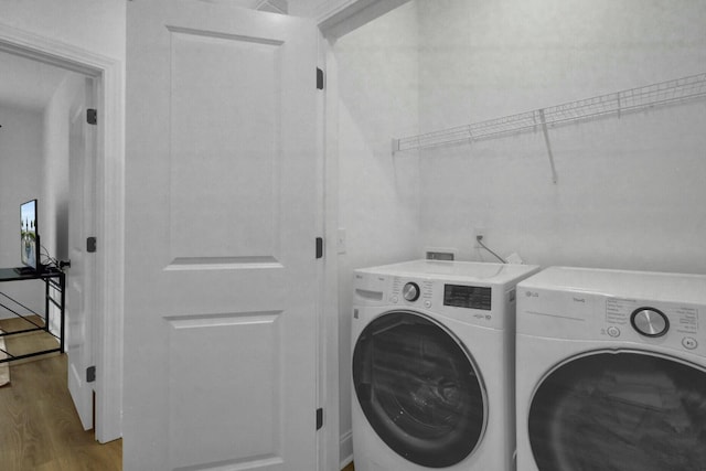 laundry area with separate washer and dryer and light hardwood / wood-style flooring