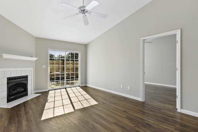 unfurnished living room with dark hardwood / wood-style floors, ceiling fan, vaulted ceiling, and a tiled fireplace