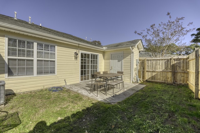 back of house with a patio and a lawn