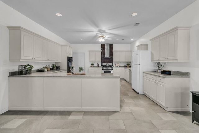 1085 Harts Bluff Rd, Wadmalaw Island, SC 29487 - kitchen with stainless steel range with gas cooktop, wall chimney exhaust hood, freestanding refrigerator, a peninsula, and ceiling fan