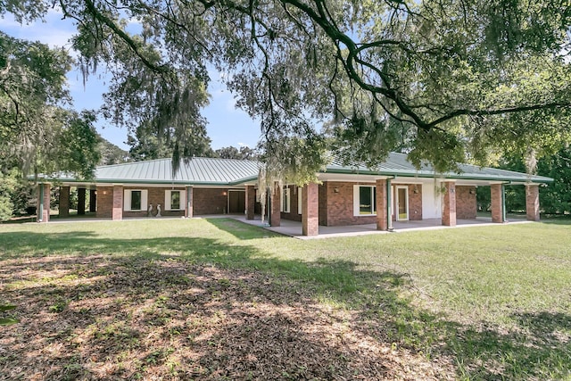 1085 Harts Bluff Rd, Wadmalaw Island, SC 29487 - view of front facade featuring brick siding, a front lawn, a carport, and a metal roof
