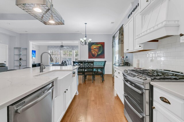 kitchen featuring white cabinets, a sink, stainless steel appliances, and custom range hood