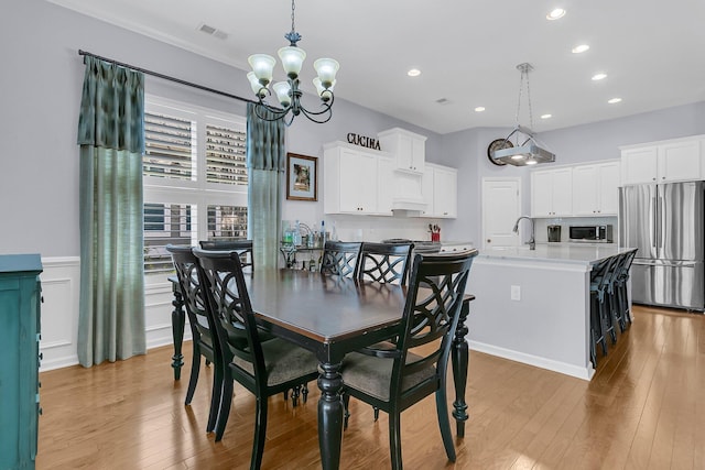 dining room featuring recessed lighting, light wood-type flooring, visible vents, and an inviting chandelier