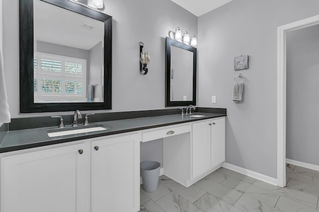 bathroom featuring marble finish floor, double vanity, visible vents, a sink, and baseboards