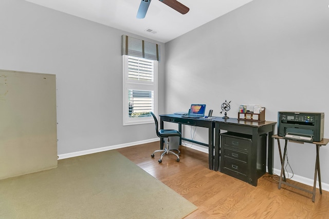 office area with wood finished floors, baseboards, a ceiling fan, and visible vents